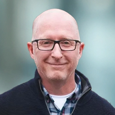 Portrait photo of Dr. Jeff Campbell D.C. smiling while wearing glasses.